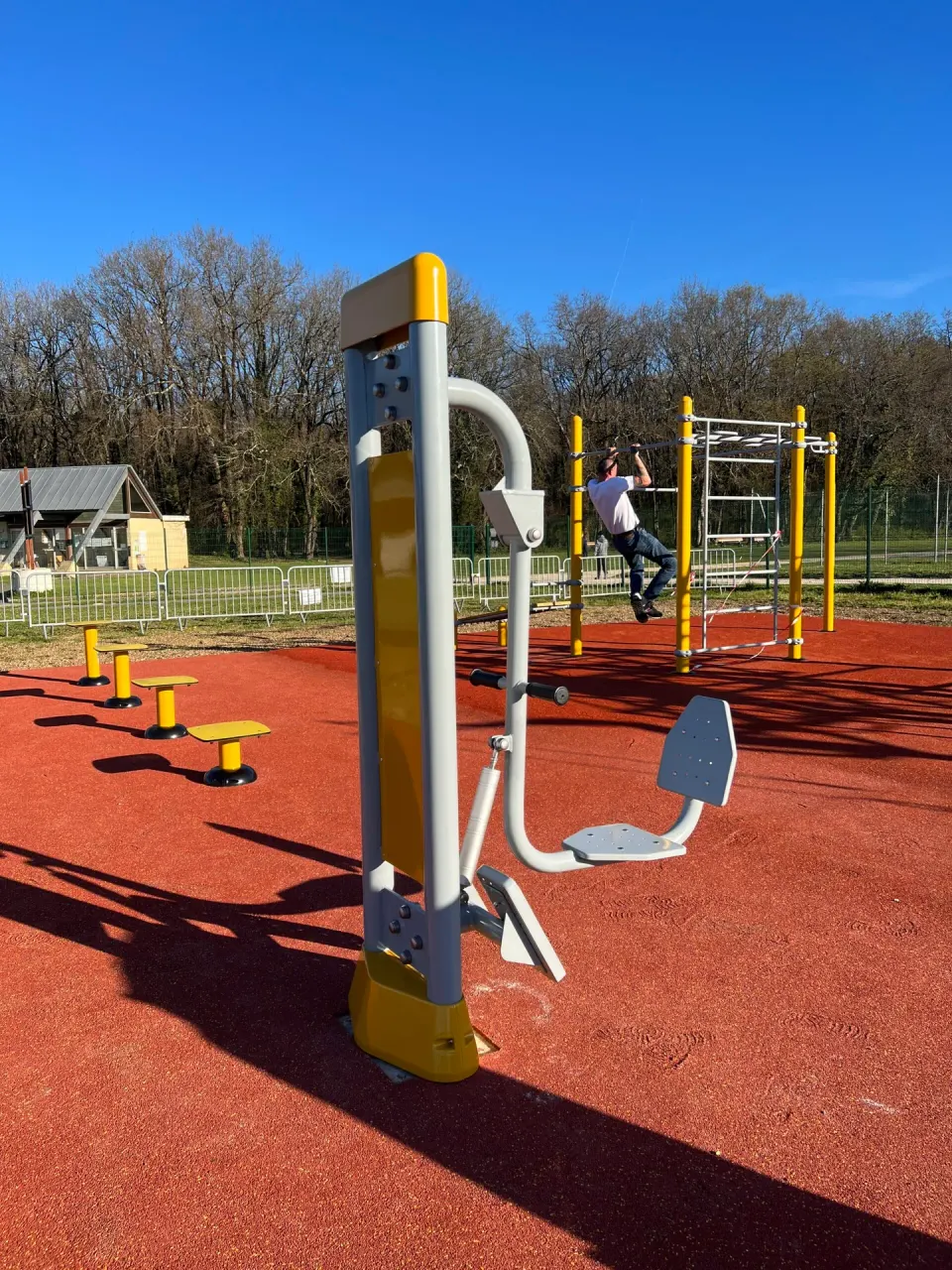Appareil de fitness extérieur Herkules sur sol amortissant rouge