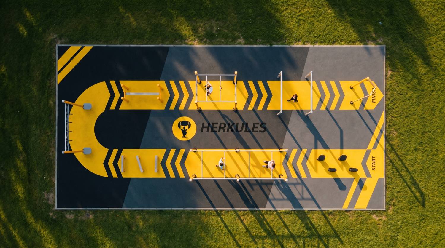 Vue aérienne d'un parcours ninja Herkules avec marquage au sol jaune et noir