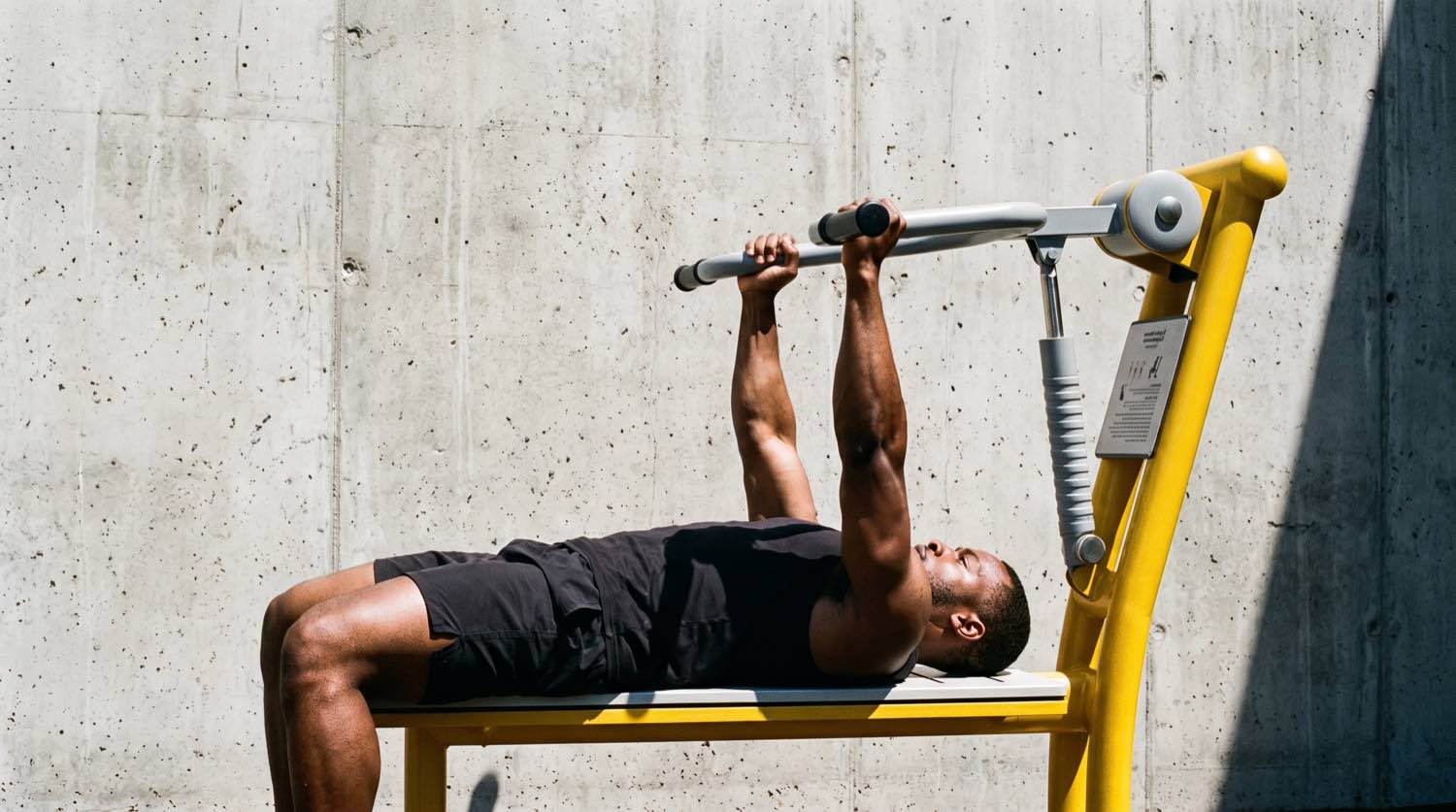 Banc de développé couché piston Herkules de profil contre un mur de béton