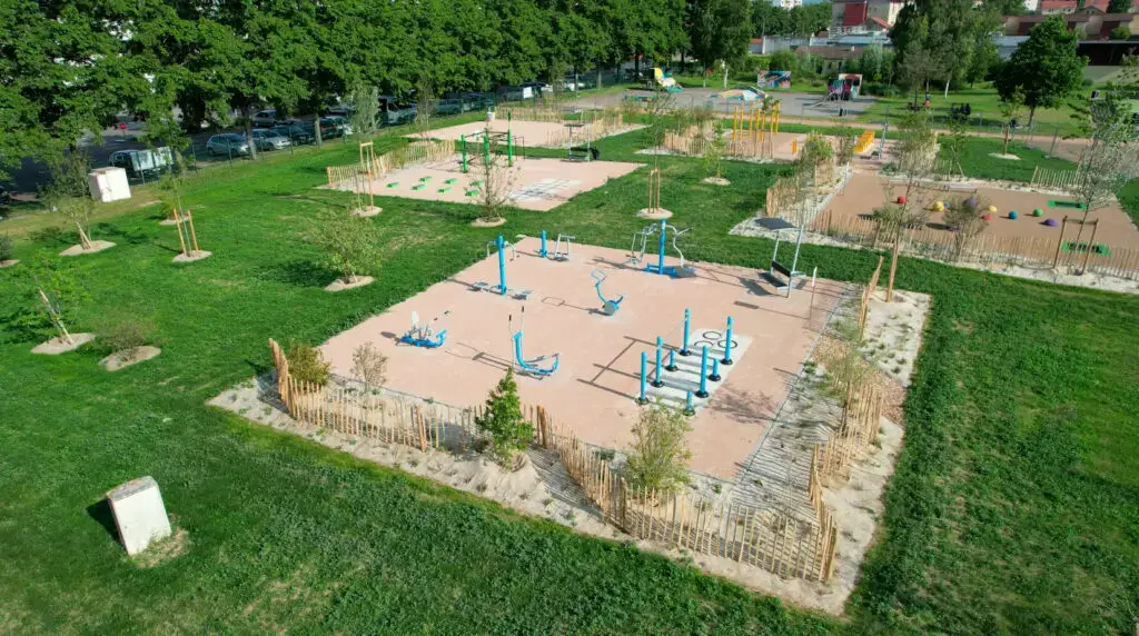 Aire de fitness extérieur communale vue du ciel, agrès posés sur un sol amortissant