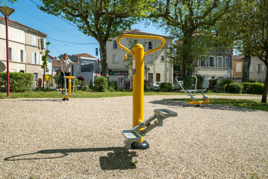 Agrès de fitness extérieur scellés dans un sol sablé, dans un square
