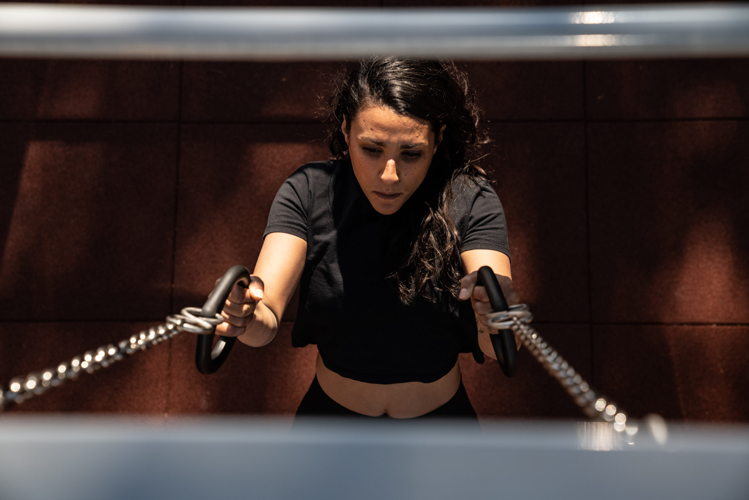 Une femme utilisant les anneaux d'une station de street workout