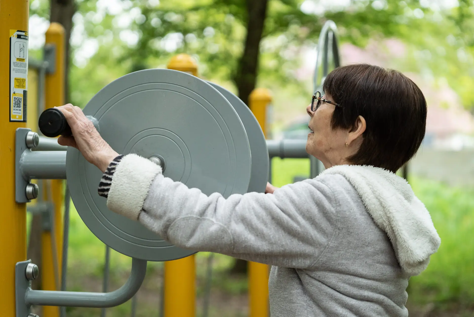 Close-up sur femme utilisant un moulinet Sport Santé Sénior/PMR Herkules Fitness dans un parc