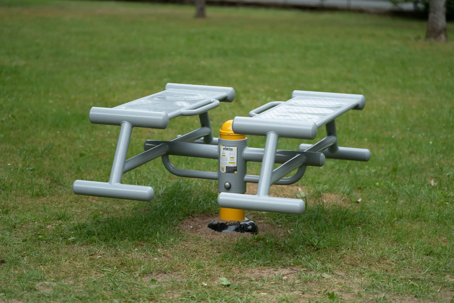 Average shot of a Herkules Fitness double abs bench in the grass in Saint-Pierre-Les-Nemours
