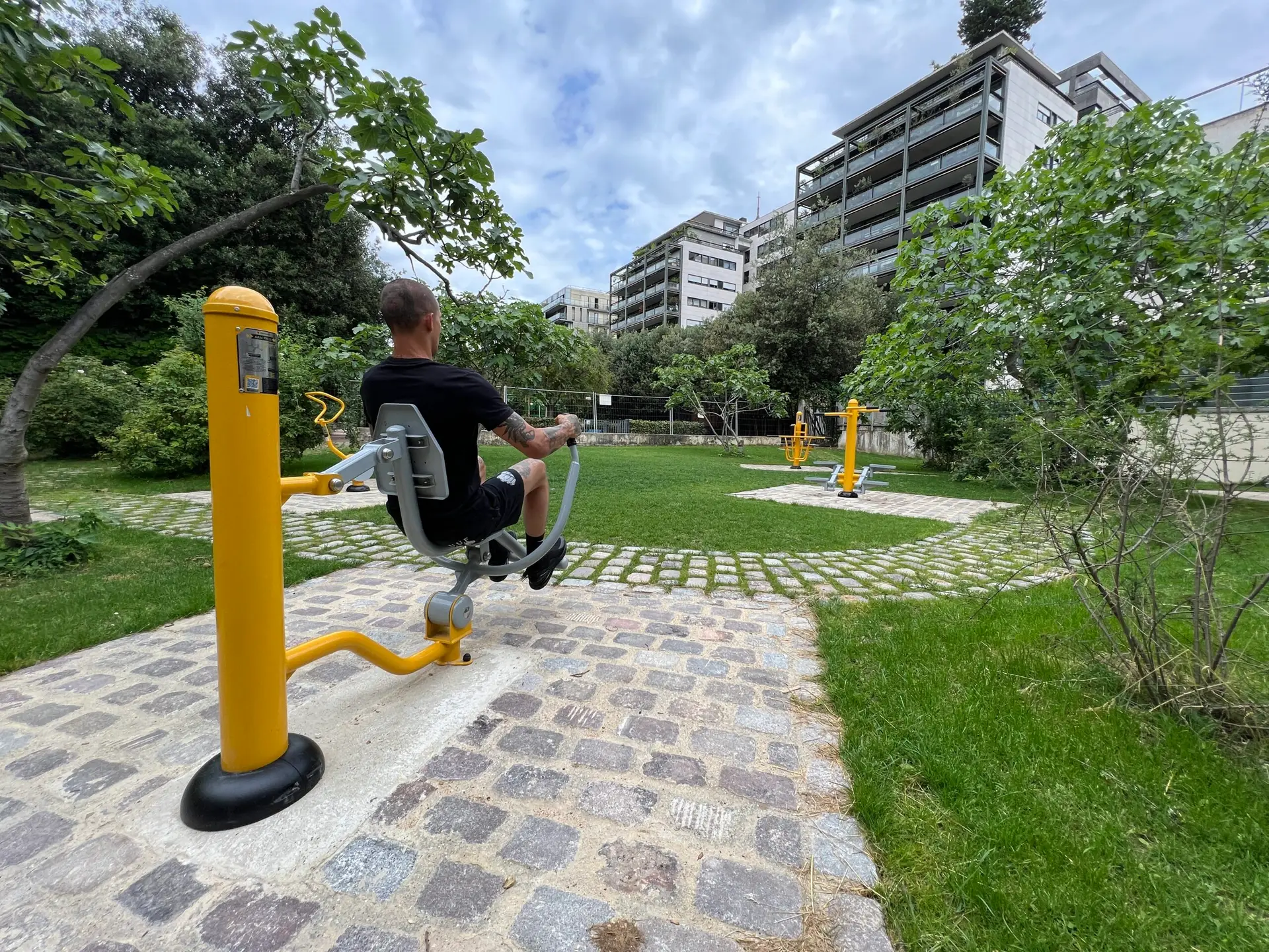 mężczyzna ćwiczący na wioślarzu na paryskim skwerze